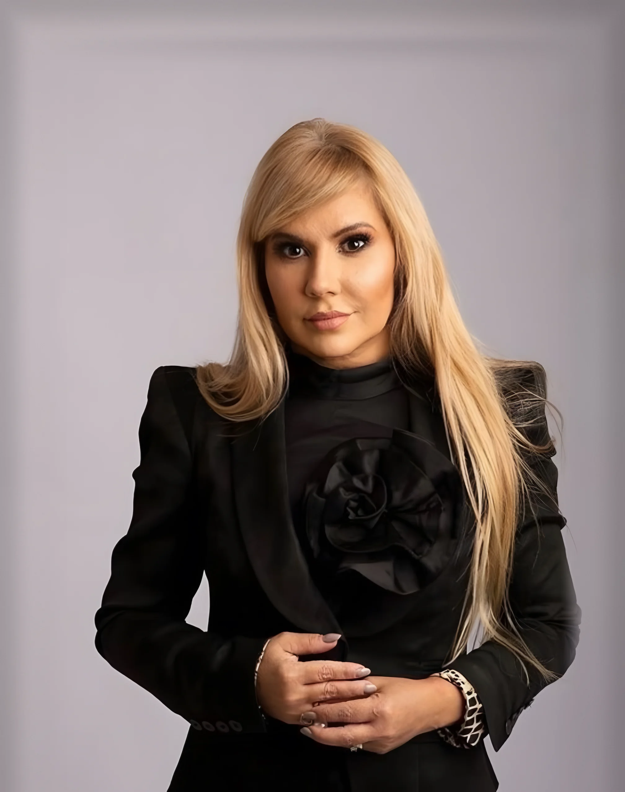 Dra. Flávia Bentes, advogada, de blazer preto em retrato de estúdio
